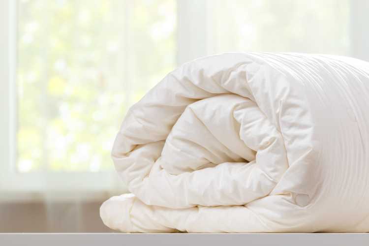 folded rolls duvet is lying on the dresser 